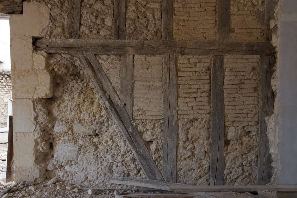 Mur ancien ouvert en cours de chantier, pierre et bois apparents