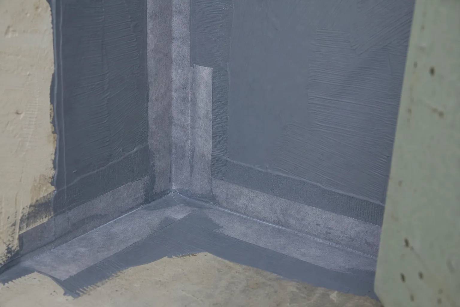 Angle de mur traité en bande d’étanchéité avant pose du carrelage dans une salle de bain