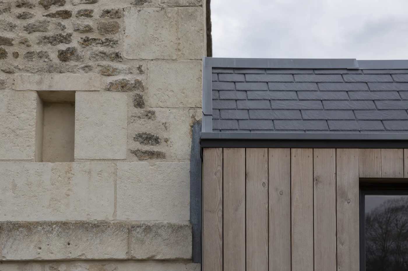 Détail de la jonction entre l’extension et la maison ancienne : joint de dilatation, raccord de couverture et rejet d’eau